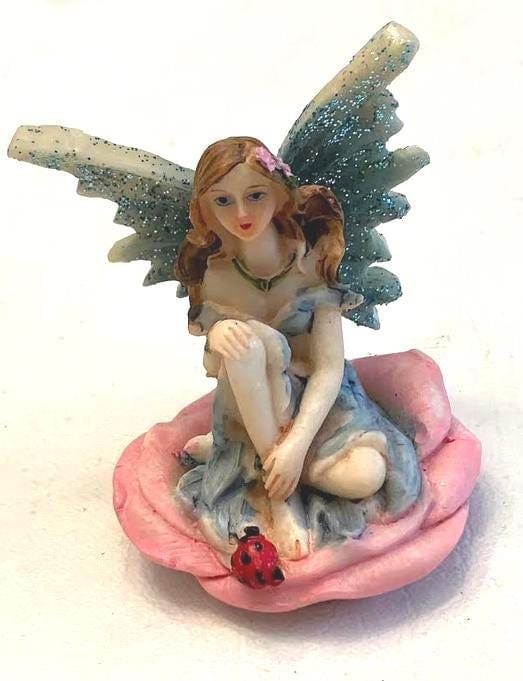 Miniature Blue Wing Fairy Sitting on a Pink Flower
