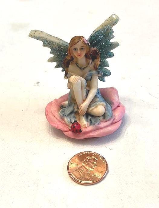 Miniature Blue Wing Fairy Sitting on a Pink Flower
